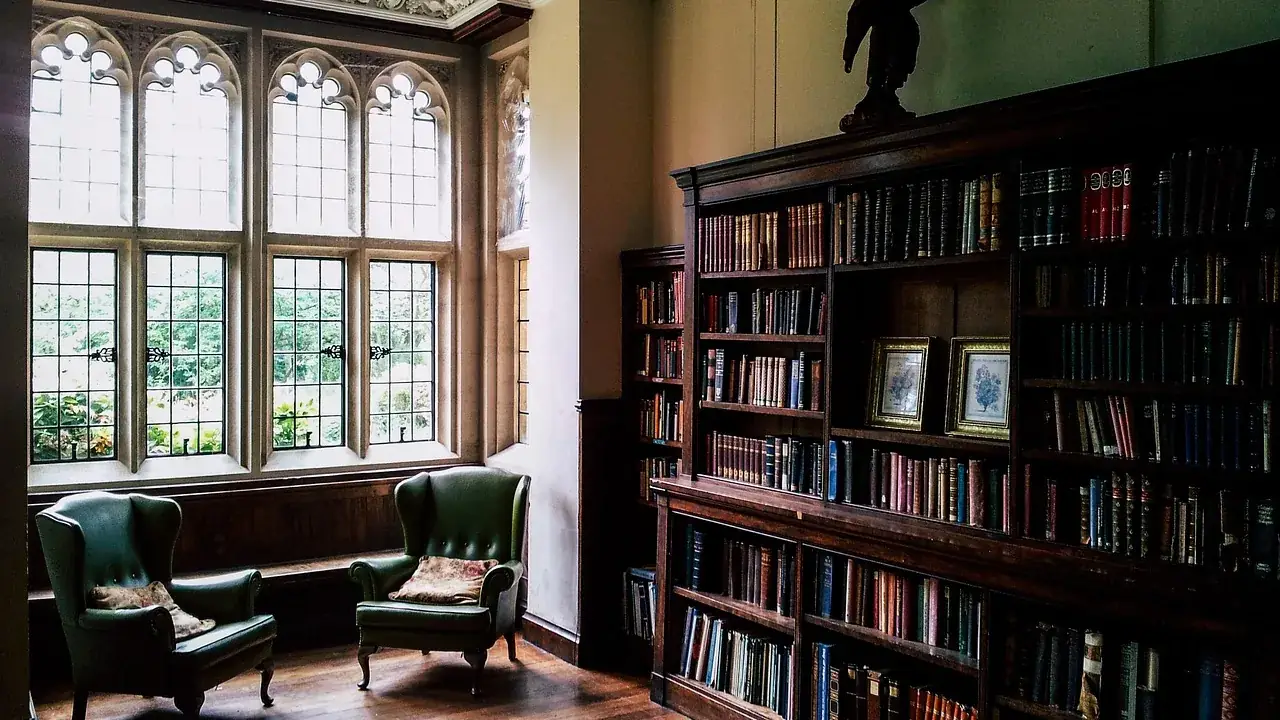 Salle de lecture d’une bibliothèque ancienne, deux fauteuils près des fenêtres